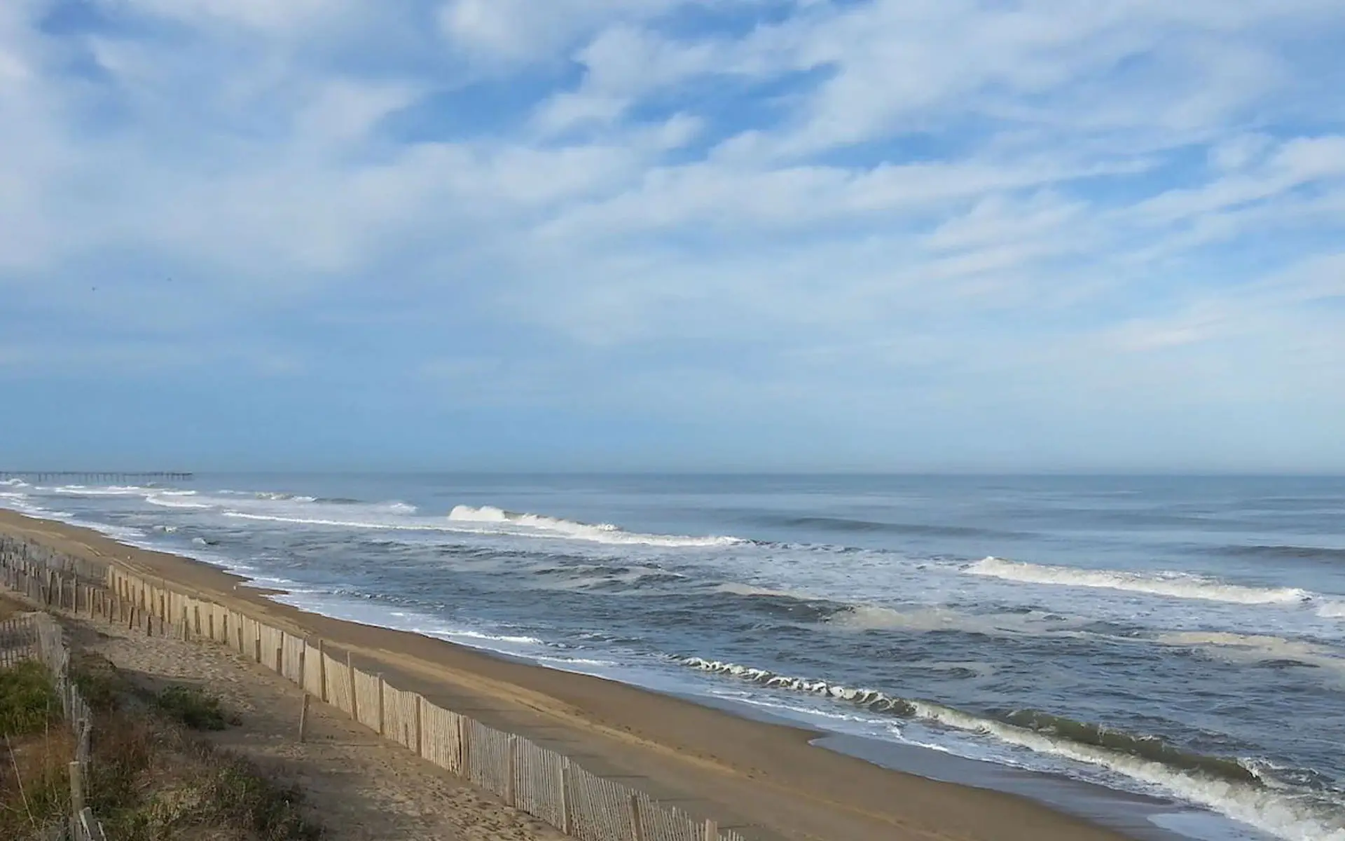 Mariner Inn & Suites, an oceanfront hotel in Kill Devil Hills, North Carolina, seen from the parking lot with the Atlantic Ocean beyond